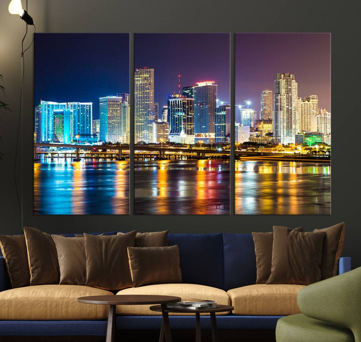 The Wall Art MIAMI Canvas Print features a stunning triptych of a city skyline at night, with vibrant lights reflecting on the water. This gallery-wrapped piece on museum-quality canvas delivers an exquisite finish.