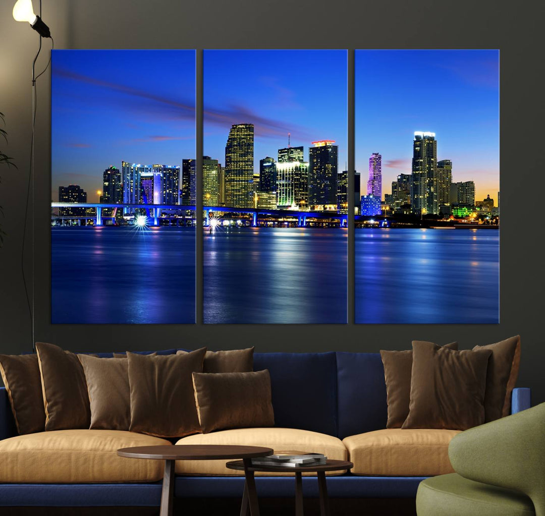 The modern living room showcases a striking Miami Blue Night Wall Art canvas print on the wall. The artwork is gallery wrapped on museum-quality canvas, ensuring durability and elegance.