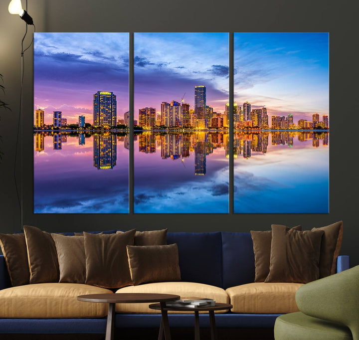 The Miami City Wall Art Canvas Print, featuring a three-panel depiction of a city skyline at sunset reflected in water, beautifully enhances the wall. Made with museum-quality canvas and a UV-protective coating, it comes ready to hang.