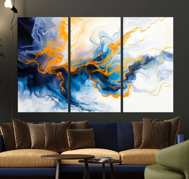 A stunning Fluid Alcohol Ink Wall Art with Gold Wall Art Canvas Print, featuring vibrant blue, orange, and white swirls, adorns the wall. This gallery-quality finish adds an exquisite touch to any living space.