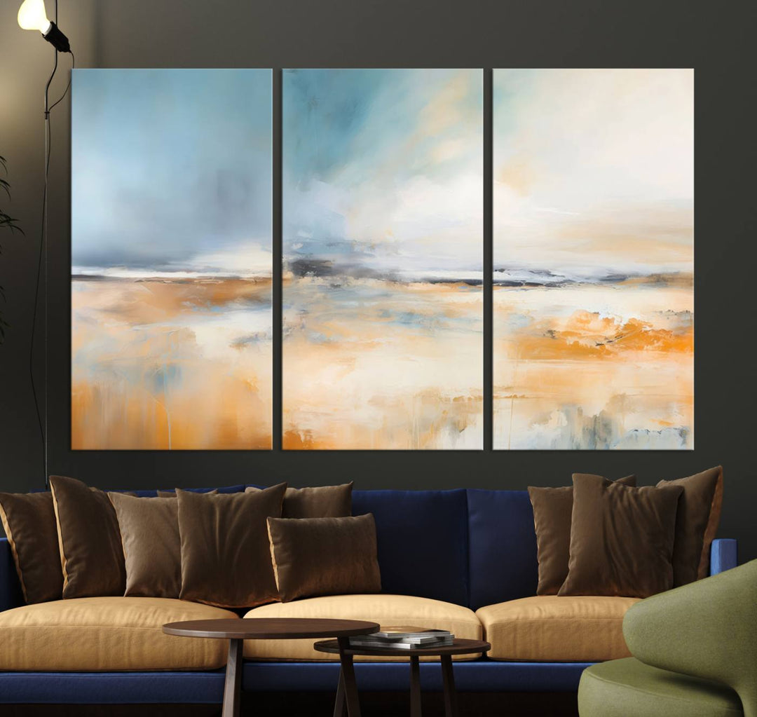 The Abstract Landscape Wall Art Canvas Print, featuring warm tones of orange and blue, is displayed on a dark wall.