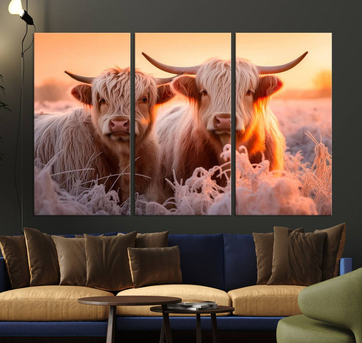 The "Highland Cows at Sunrise Wall Art Canvas Set" beautifully captures a serene and rustic farmhouse aesthetic, portraying two Highland cows in a frosty landscape at sunrise.