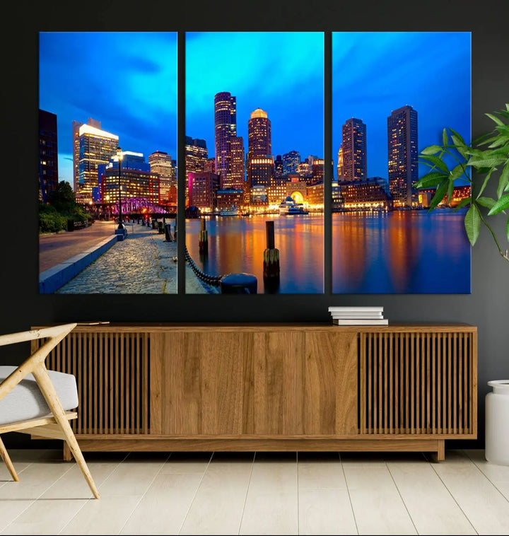 A triptych of the "Boston City Lights Night Blue Skyline Cityscape View Wall Art Canvas Print" adorns the wall. This museum-quality canvas artwork is ready to hang and includes a UV-protective coating for lasting brilliance.