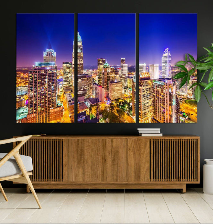 A modern living room features the Charlotte City Lights Night Blue Skyline Cityscape View wall art canvas print.