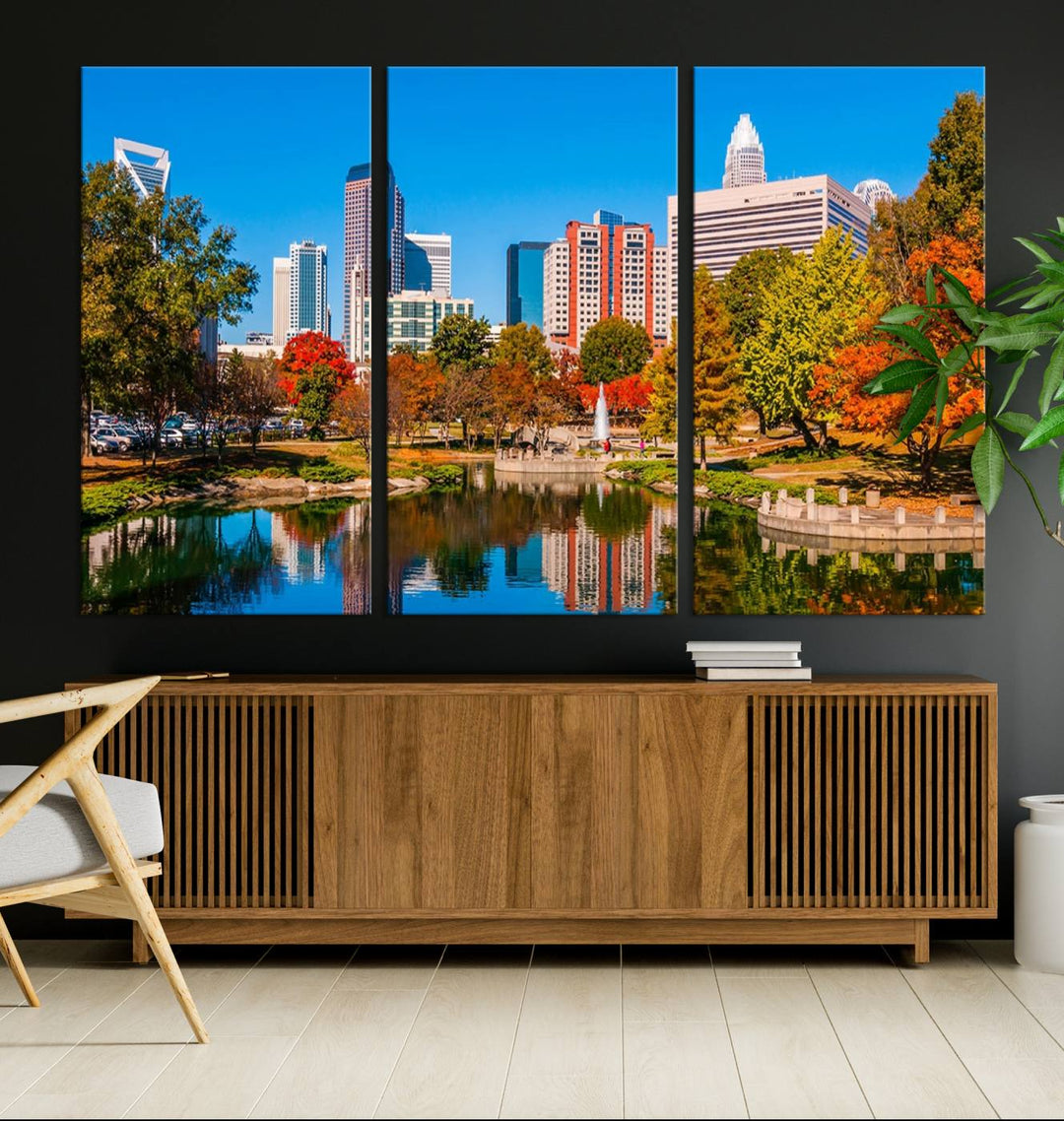 The Charlotte City Park at Fall Skyline Cityscape View wall art canvas print features a city panorama with a park and lake accented by autumn trees. It is mounted on museum-quality canvas with UV-protective coating and decorates the space.