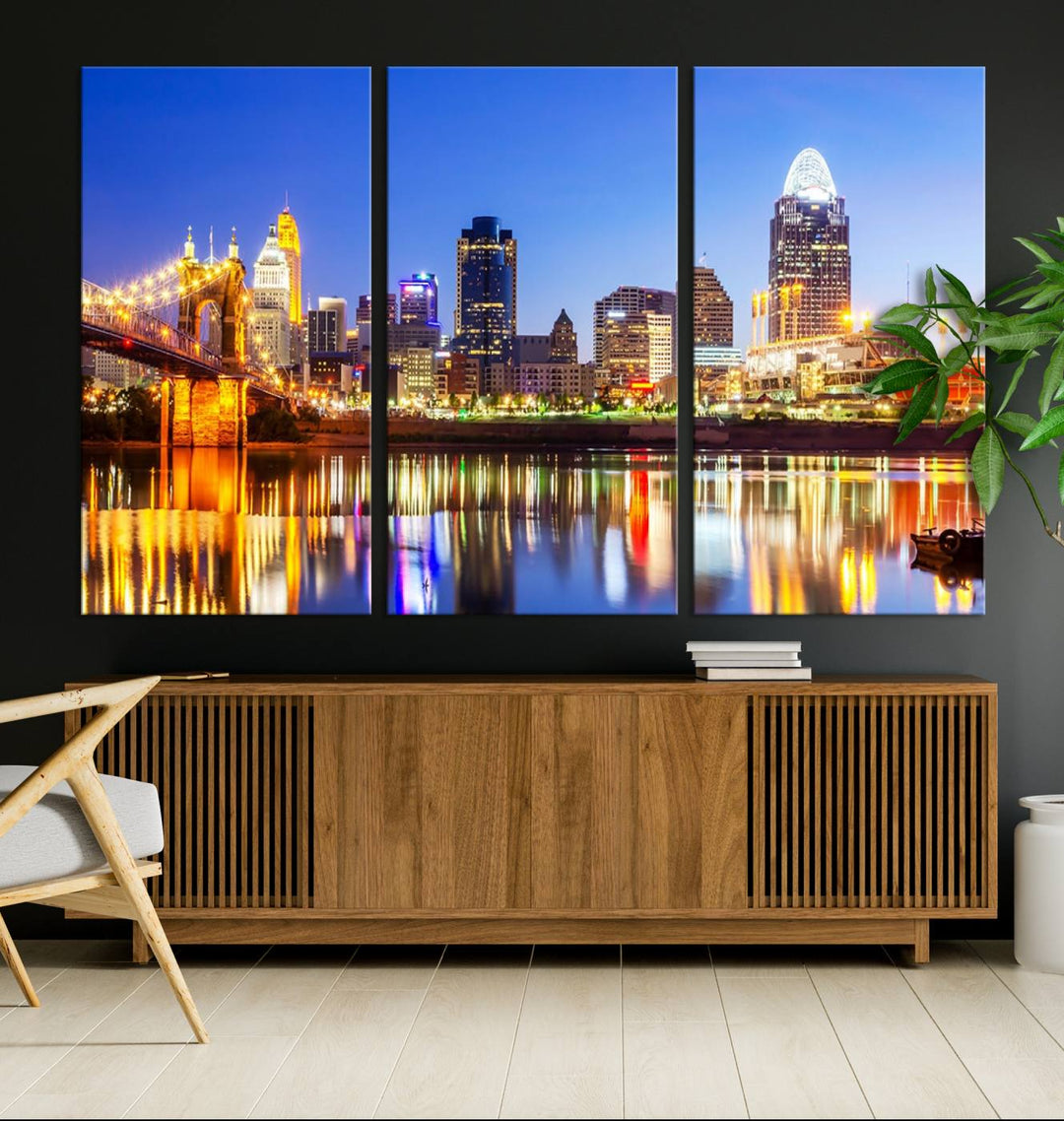 The "Cincinnati City Lights Night Skyline Cityscape View Wall Art Canvas Print" is a gallery-wrapped, museum-quality canvas illustrating a lit-up bridge and skyline at night. Enhanced with a UV-protective coating, this piece ensures lasting vibrancy.