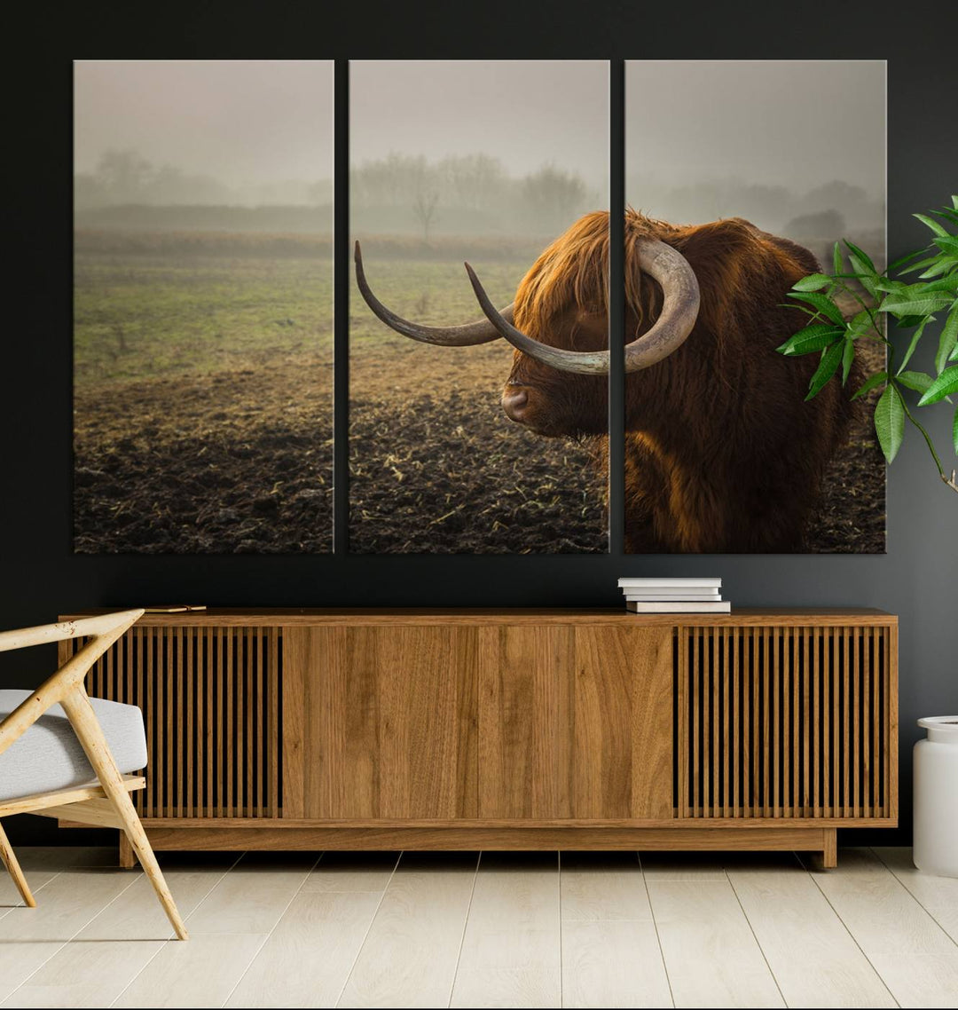 The "Big Cow Horn Wall Art Canvas Print" is a hand-assembled framed canvas depicting a Highland cow in a misty field. It is crafted with a UV-protective coating to ensure lasting vibrancy.