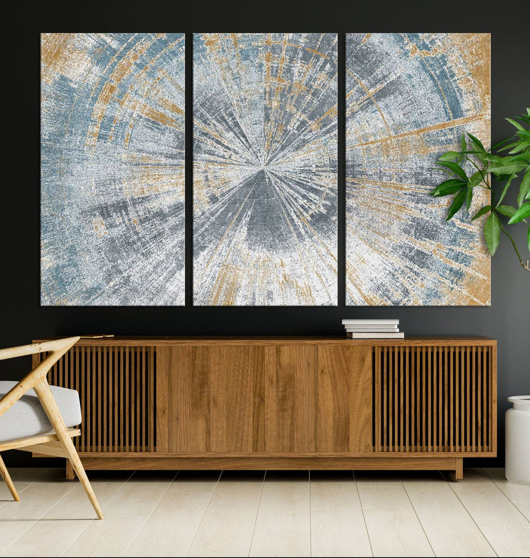 The Radiant Abstract Wood Rings Canvas Art, a modern triptych wall decor, enhances the contemporary style of the living room with its blue, white, and gold hues.