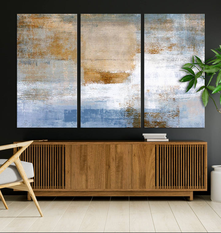 The Blue Multi Panel Abstract Wall Art Canvas Print, featuring an elegant blend of blue, beige, and brown tones, hangs gracefully on the wall, adding a contemporary touch to the space.