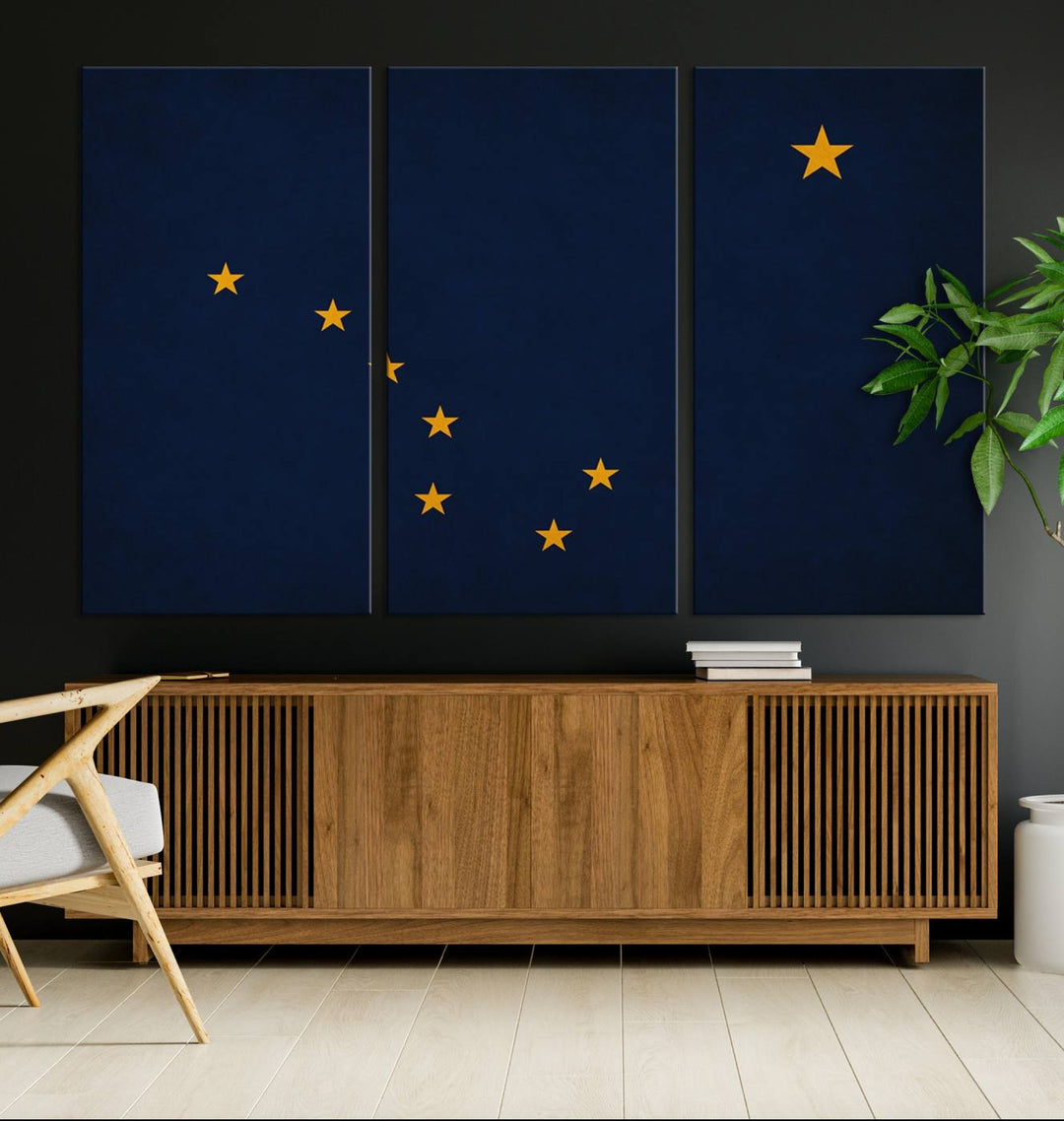 A contemporary living room featuring a triptych artwork of stars on a navy background, accentuated by the striking Alaska States Flag Wall Art Canvas Print.