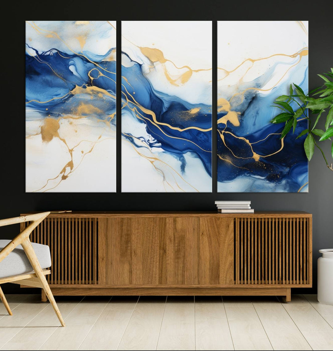 The Blue Abstract Wall Art is displayed as a triptych on museum-quality canvas, showcasing a blue and gold abstract design. The artwork includes a UV-protective coating to maintain its vibrancy and comes with the benefit of free shipping.