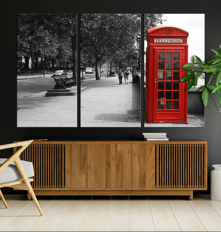 The London Phone Club Wall Art is a stunning piece that showcases a red telephone box set in a black and white street scene on museum-quality canvas. It is gallery wrapped with a UV-protective coating to preserve its vibrant charm.