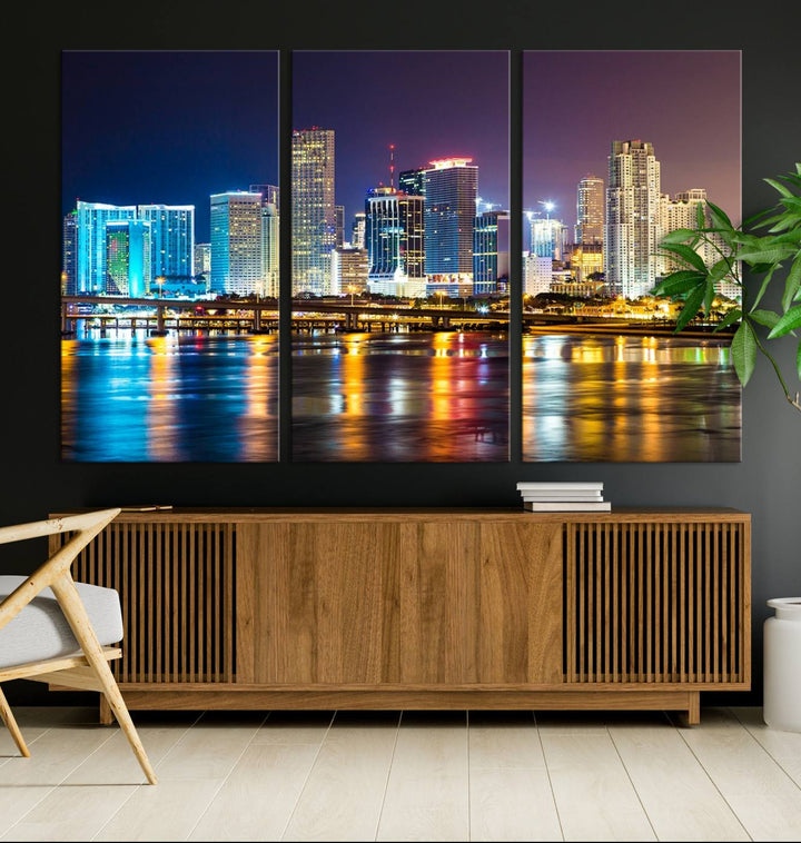 The Wall Art MIAMI Canvas Print features a stunning triptych of a city skyline at night, with vibrant lights reflecting on the water. This gallery-wrapped piece on museum-quality canvas delivers an exquisite finish.