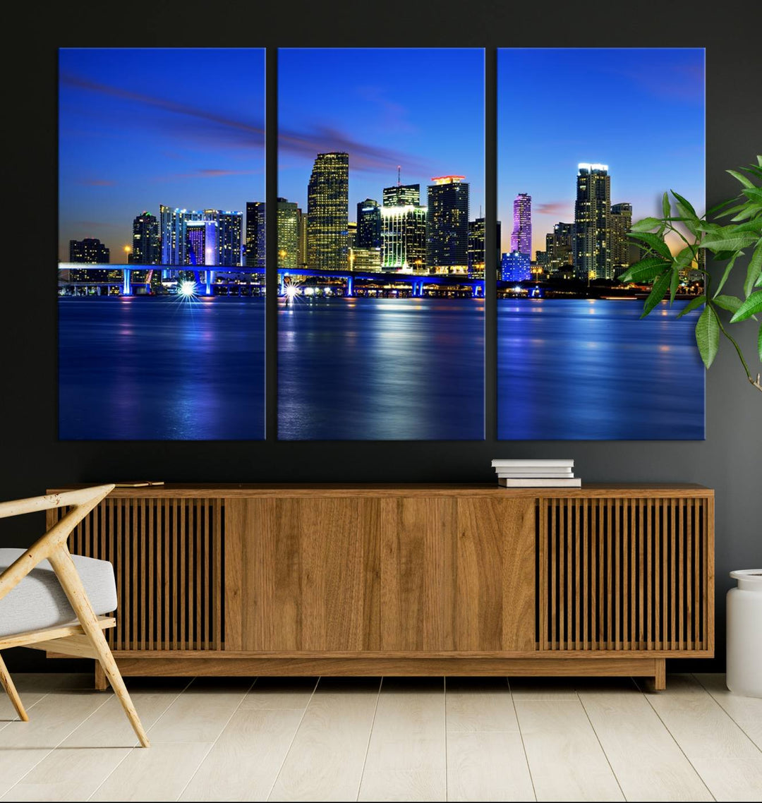 The modern living room showcases a striking Miami Blue Night Wall Art canvas print on the wall. The artwork is gallery wrapped on museum-quality canvas, ensuring durability and elegance.