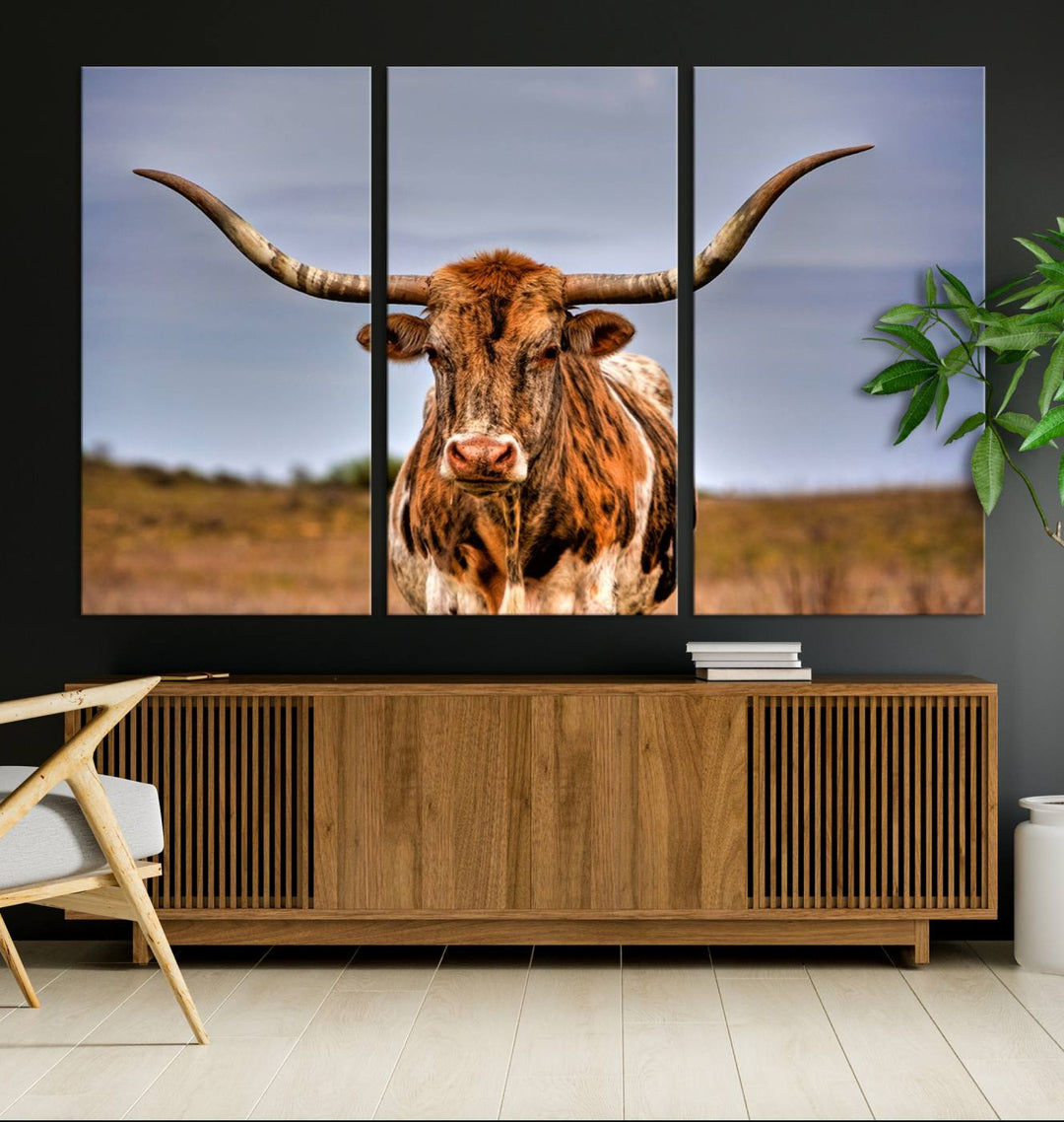 The Texas Longhorn Wall Art Print, a triptych canvas artwork depicting a longhorn bull in a field, features a gallery-quality finish.