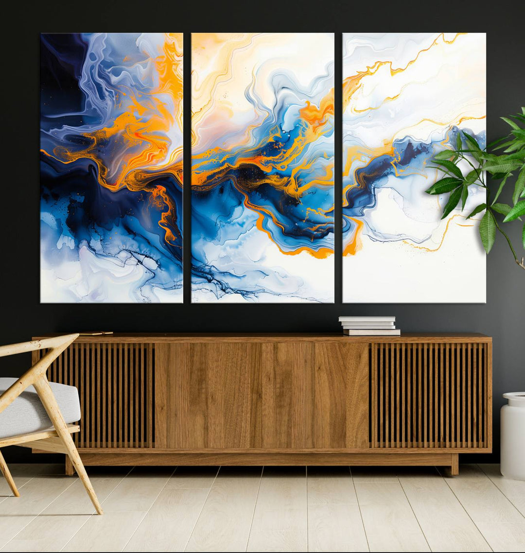 A stunning Fluid Alcohol Ink Wall Art with Gold Wall Art Canvas Print, featuring vibrant blue, orange, and white swirls, adorns the wall. This gallery-quality finish adds an exquisite touch to any living space.