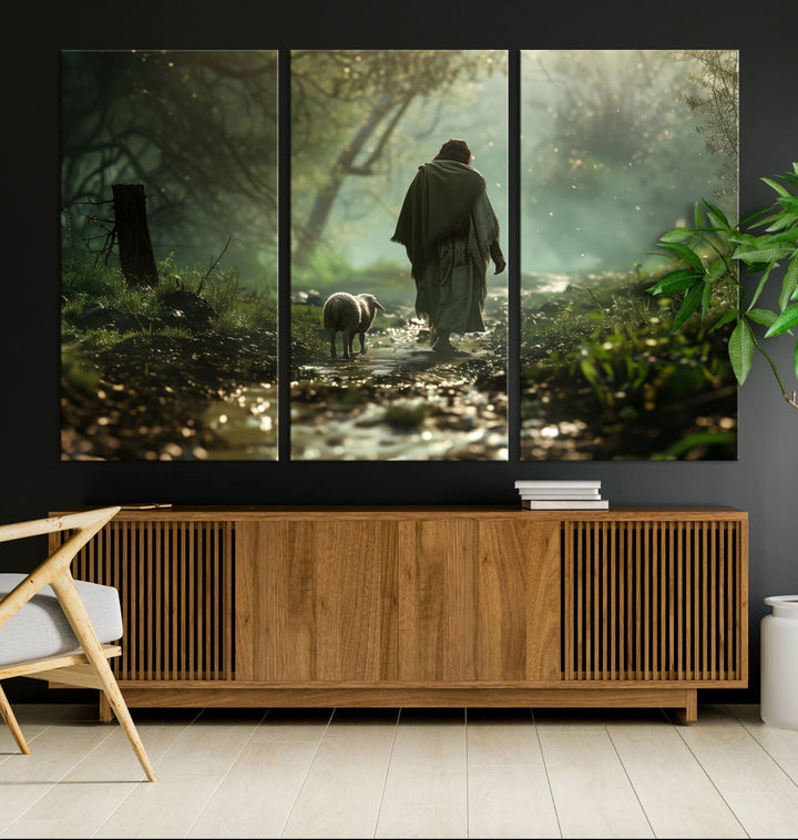 The wall art piece, titled "Jesus Shepherd a Lost Lamb Canvas Wall Art Print," is suspended on the wall and depicts a robed figure and a lamb wandering along a forest path.