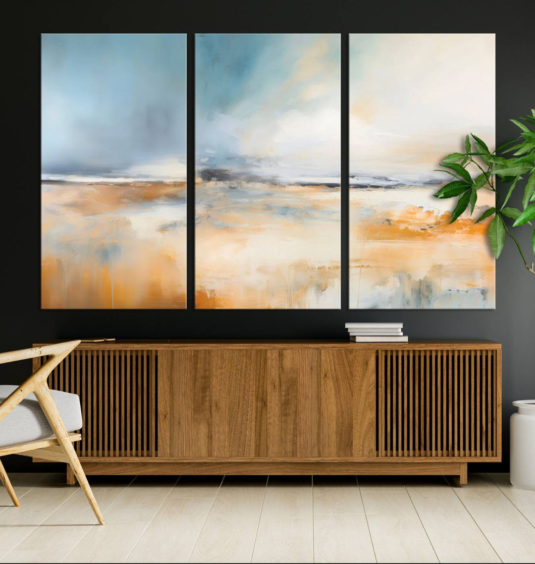 The Abstract Landscape Wall Art Canvas Print, featuring warm tones of orange and blue, is displayed on a dark wall.