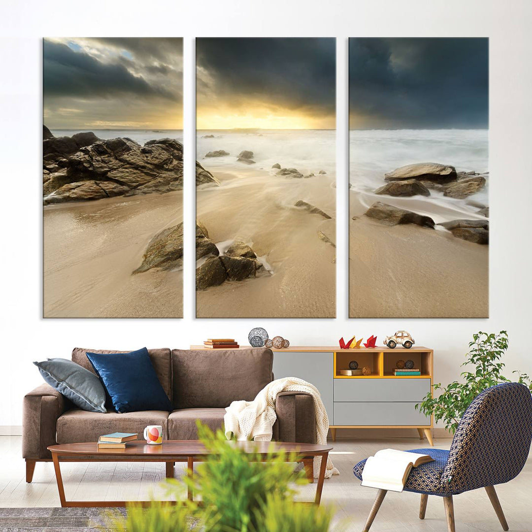 A gallery-wrapped, three-panel artwork titled "Rocks and Waves Wall Art Canvas Print" depicts a rocky beach at sunset. Each canvas showcases museum-quality craftsmanship and a UV-protective coating to maintain its vibrant colors.