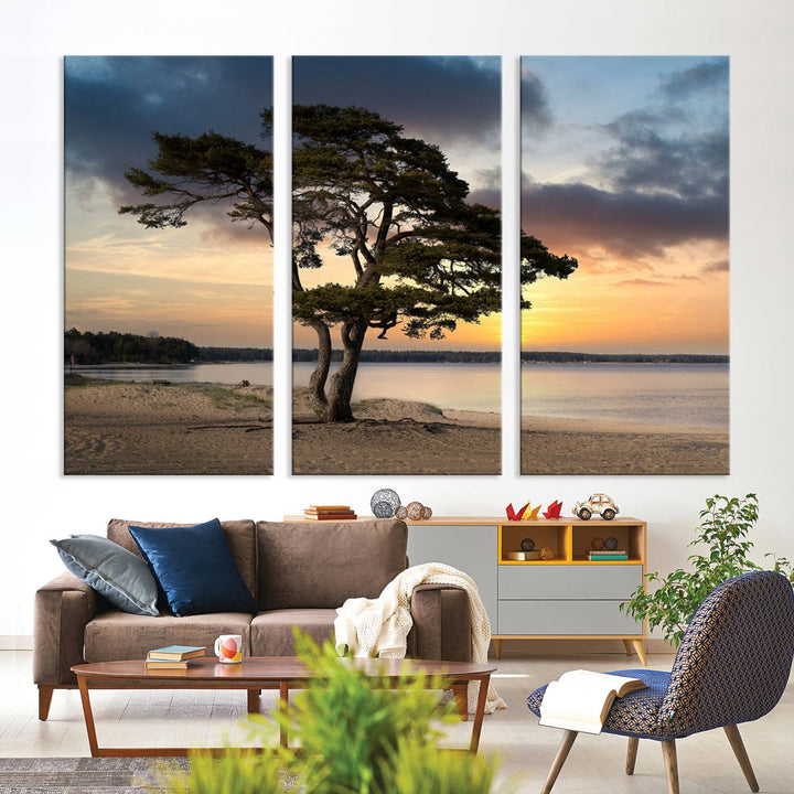 The room showcases the Coastal Sunset Wall Art Canvas Print, a triptych elegantly displayed on museum-quality polycotton canvas, depicting a serene beach sunset with a tree.