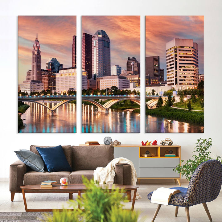 The "Columbus City Lights Sunset Orange Cloudy Skyline Cityscape View" wall art is featured on the wall. This triptych is printed on museum-quality canvas and includes a UV-protective coating, ensuring lasting vibrancy.