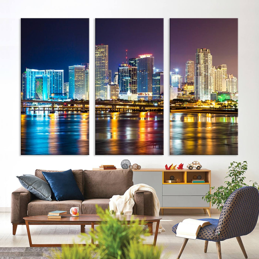 The Wall Art MIAMI Canvas Print features a stunning triptych of a city skyline at night, with vibrant lights reflecting on the water. This gallery-wrapped piece on museum-quality canvas delivers an exquisite finish.