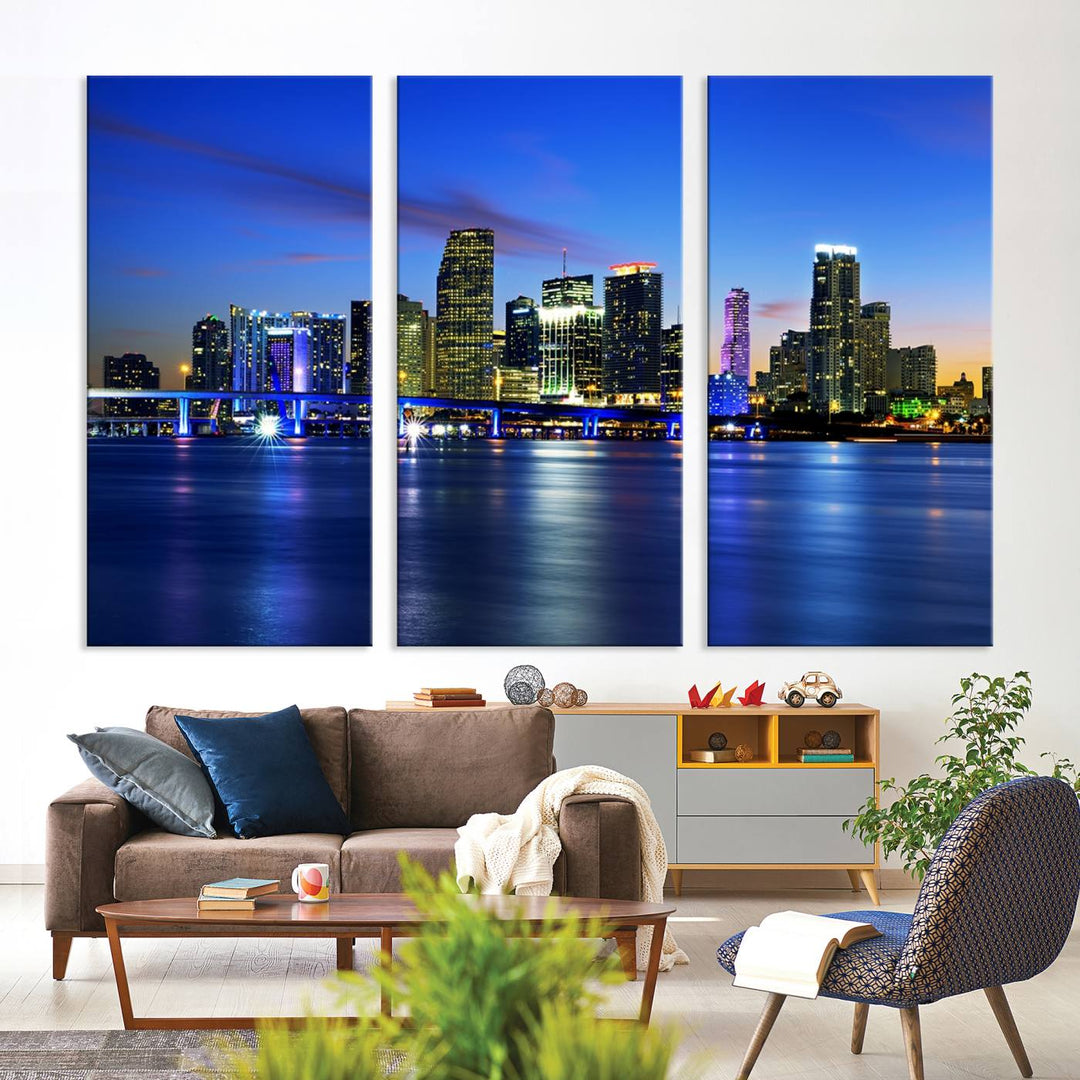 The modern living room showcases a striking Miami Blue Night Wall Art canvas print on the wall. The artwork is gallery wrapped on museum-quality canvas, ensuring durability and elegance.