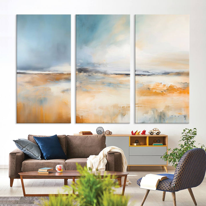 The Abstract Landscape Wall Art Canvas Print, featuring warm tones of orange and blue, is displayed on a dark wall.