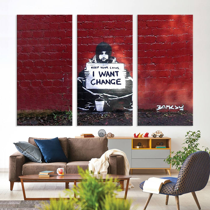 The living room showcases a triptych of stencil artwork on museum-quality canvas, featuring the Banksy I Want Change Graffiti Abstract Wall Art Canvas Print. This captivating piece depicts a person holding a sign that says "I want change" and is finished with a UV-protective coating to ensure long-lasting beauty.