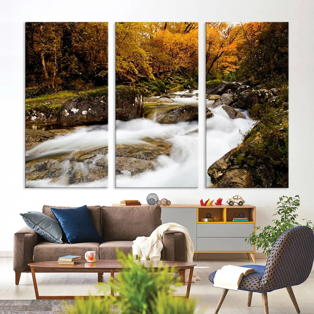 The living room is adorned with the "Wall Art Waterfall Canvas Print River in Forest in Autumn," a triptych on museum-quality canvas showcasing a flowing river surrounded by autumn trees. This ready-to-hang artwork features a UV-protective coating to ensure enduring vibrancy.