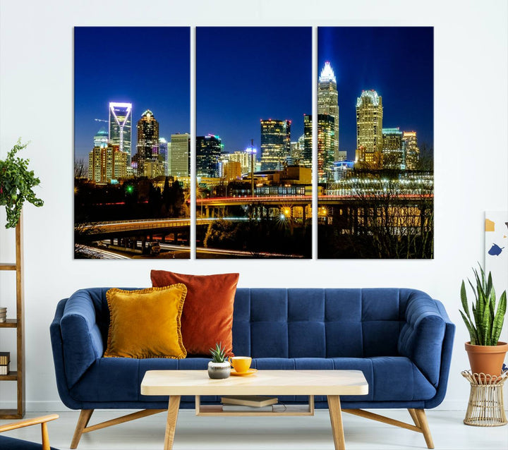 The Charlotte City Lights Night Blue Skyline Cityscape View Wall Art Canvas Print, showcasing an illuminated city skyline at night, is printed on museum-quality canvas with a UV-protective coating. Enhance your space with this stunning piece and enjoy free shipping with your purchase.