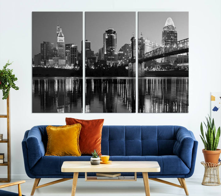 The wall showcases a ready-to-hang triptych of the Cincinnati City Lights Skyline in black and white, printed on museum-quality canvas.