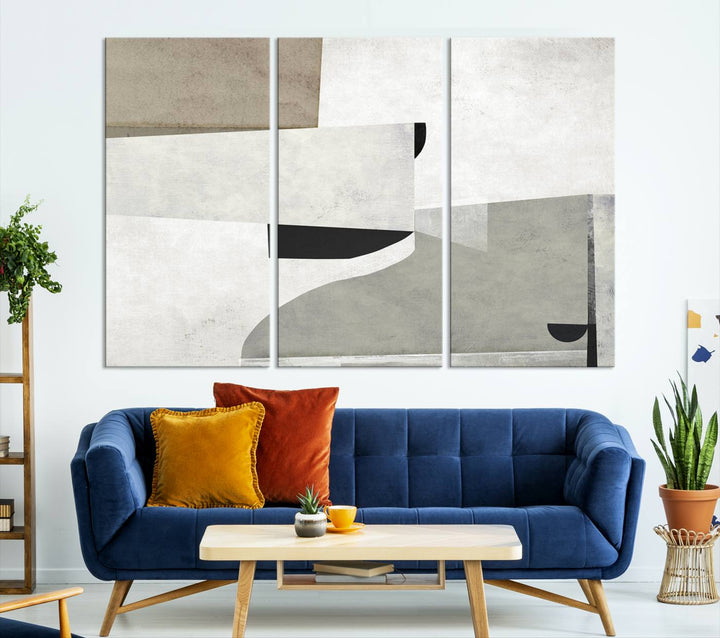 The Brown Gray Figures Abstract Wall Art Canvas Print is displayed as a triptych on a dark wall. The piece is gallery wrapped, offering a seamless finish and enhanced durability due to its UV-protective coating.