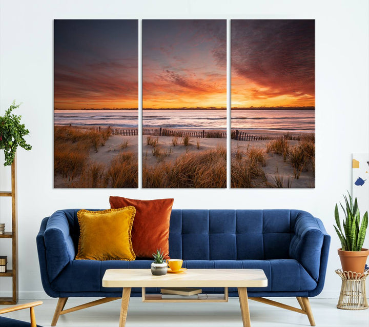 Sunset on The Beach Wall Art Canvas Print features a triptych of a beach at sunset with vivid orange skies, presented on museum-quality canvas. Each section is gallery wrapped, offering lasting beauty with its UV-protective coating.