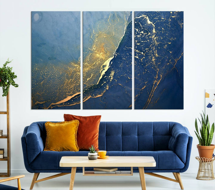 The Navy Blue Yellow Twinkle Wall Art Canvas Print, featuring an abstract design in gold and blue, enhances a modern living room as it adorns a white wall with its gallery-wrapped, museum-quality canvases for an exquisite touch.