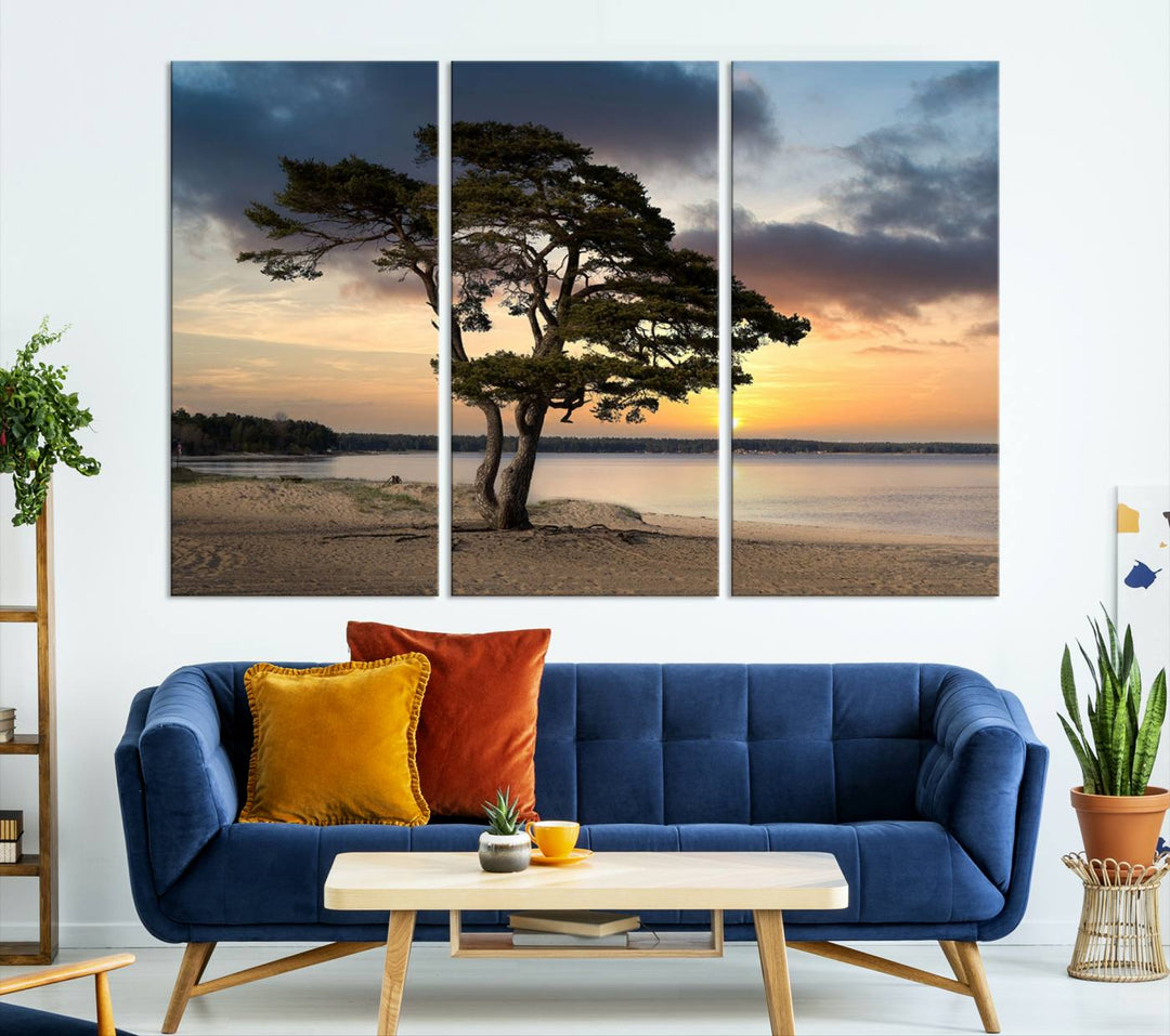 The room showcases the Coastal Sunset Wall Art Canvas Print, a triptych elegantly displayed on museum-quality polycotton canvas, depicting a serene beach sunset with a tree.