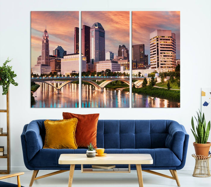 The "Columbus City Lights Sunset Orange Cloudy Skyline Cityscape View" wall art is featured on the wall. This triptych is printed on museum-quality canvas and includes a UV-protective coating, ensuring lasting vibrancy.