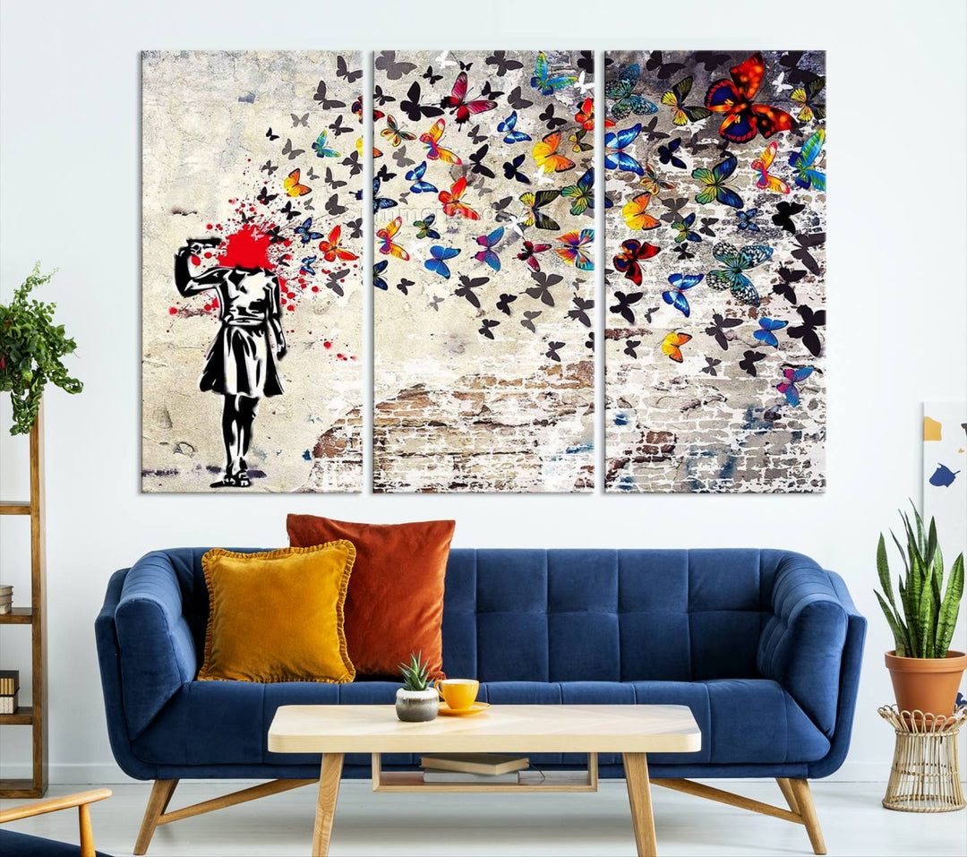 The Banksy Art Butterfly Girl Explosion Canvas showcases a dynamic figure with butterflies bursting from their head, set against a textured wall background. This vibrant urban graffiti piece is perfect for modern interiors and comes ready to hang.