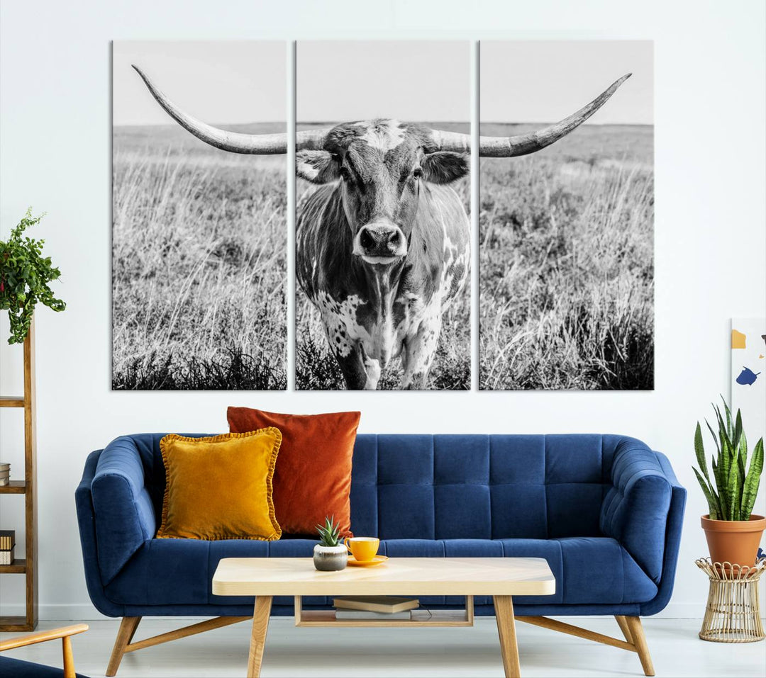 The Texas Cow Longhorn Wall Art Canvas Print is a black and white triptych depicting a cow in a field. It is crafted with museum-quality canvas and features a UV-protective coating.