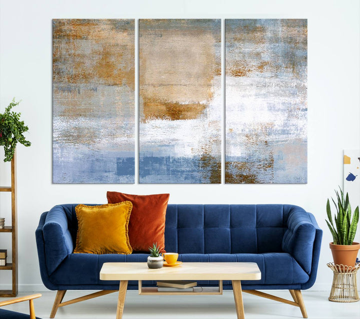 The Blue Multi Panel Abstract Wall Art Canvas Print, featuring an elegant blend of blue, beige, and brown tones, hangs gracefully on the wall, adding a contemporary touch to the space.