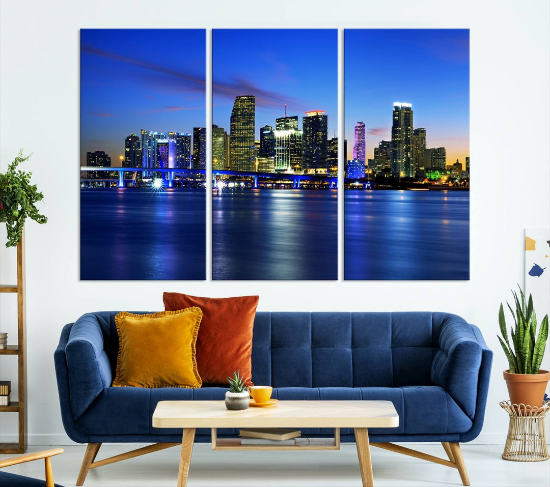 The modern living room showcases a striking Miami Blue Night Wall Art canvas print on the wall. The artwork is gallery wrapped on museum-quality canvas, ensuring durability and elegance.