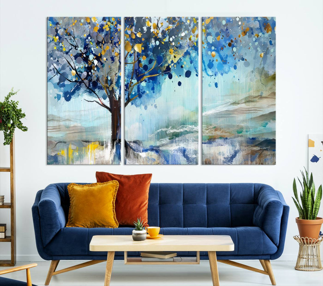 A modern living room features a three-panel Watercolor Style Abstract Tree Printing Wall Art Canvas in vibrant blue and yellow, crafted on museum-quality material.