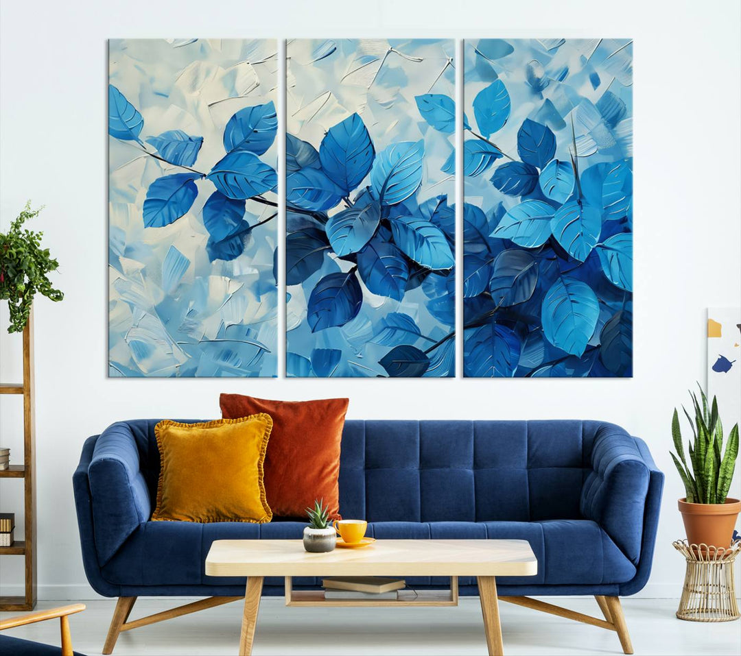 The contemporary living room is highlighted by the Abstract Blue Leaf Wall Art Canvas Print on the wall. The hand-assembled framed art enhances the room's vibrant decor, crafting a gallery-worthy ambience.