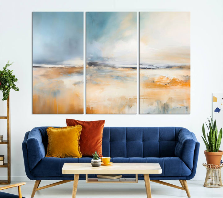 The Abstract Landscape Wall Art Canvas Print, featuring warm tones of orange and blue, is displayed on a dark wall.