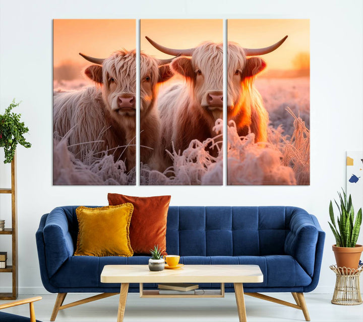 The "Highland Cows at Sunrise Wall Art Canvas Set" beautifully captures a serene and rustic farmhouse aesthetic, portraying two Highland cows in a frosty landscape at sunrise.