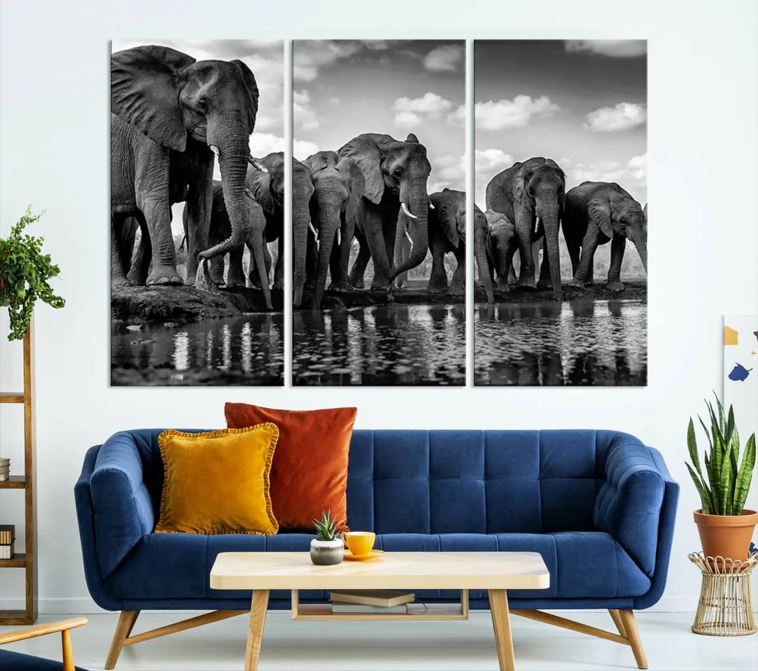 A stunning "Wall Art Animal Canvas Print" featuring a black and white photo of a herd of elephants drinking water is elegantly displayed, gallery wrapped on museum-quality canvas.