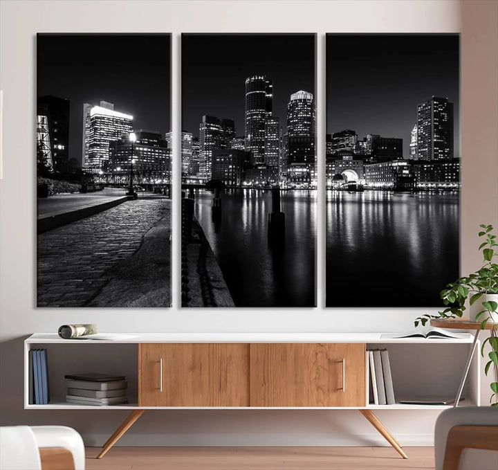 The Boston City Lights Skyline Black and White Wall Art Cityscape Canvas Print portrays a triptych of the city skyline at night reflecting on a calm river. This museum-quality canvas features UV-protective finishes to preserve its timeless allure.