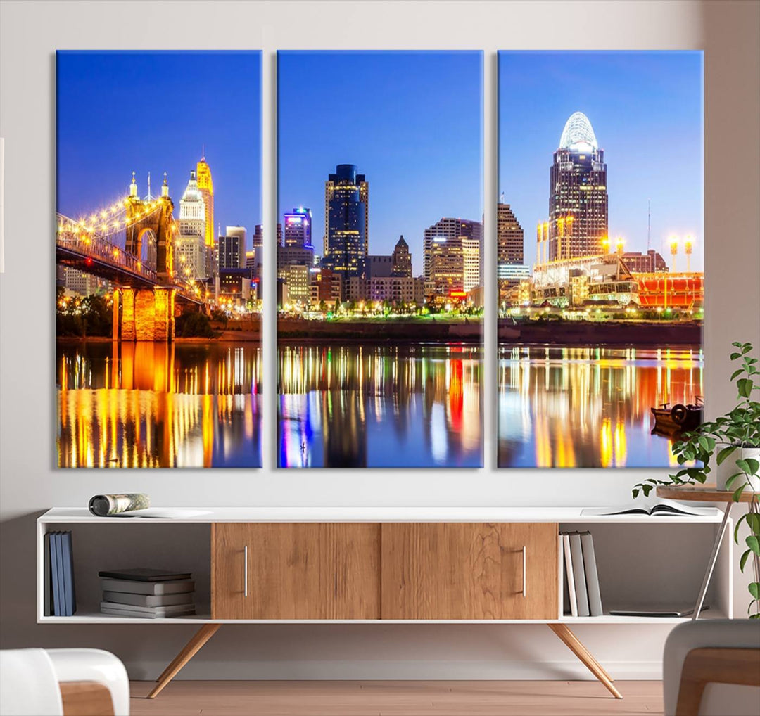 The "Cincinnati City Lights Night Skyline Cityscape View Wall Art Canvas Print" is a gallery-wrapped, museum-quality canvas illustrating a lit-up bridge and skyline at night. Enhanced with a UV-protective coating, this piece ensures lasting vibrancy.