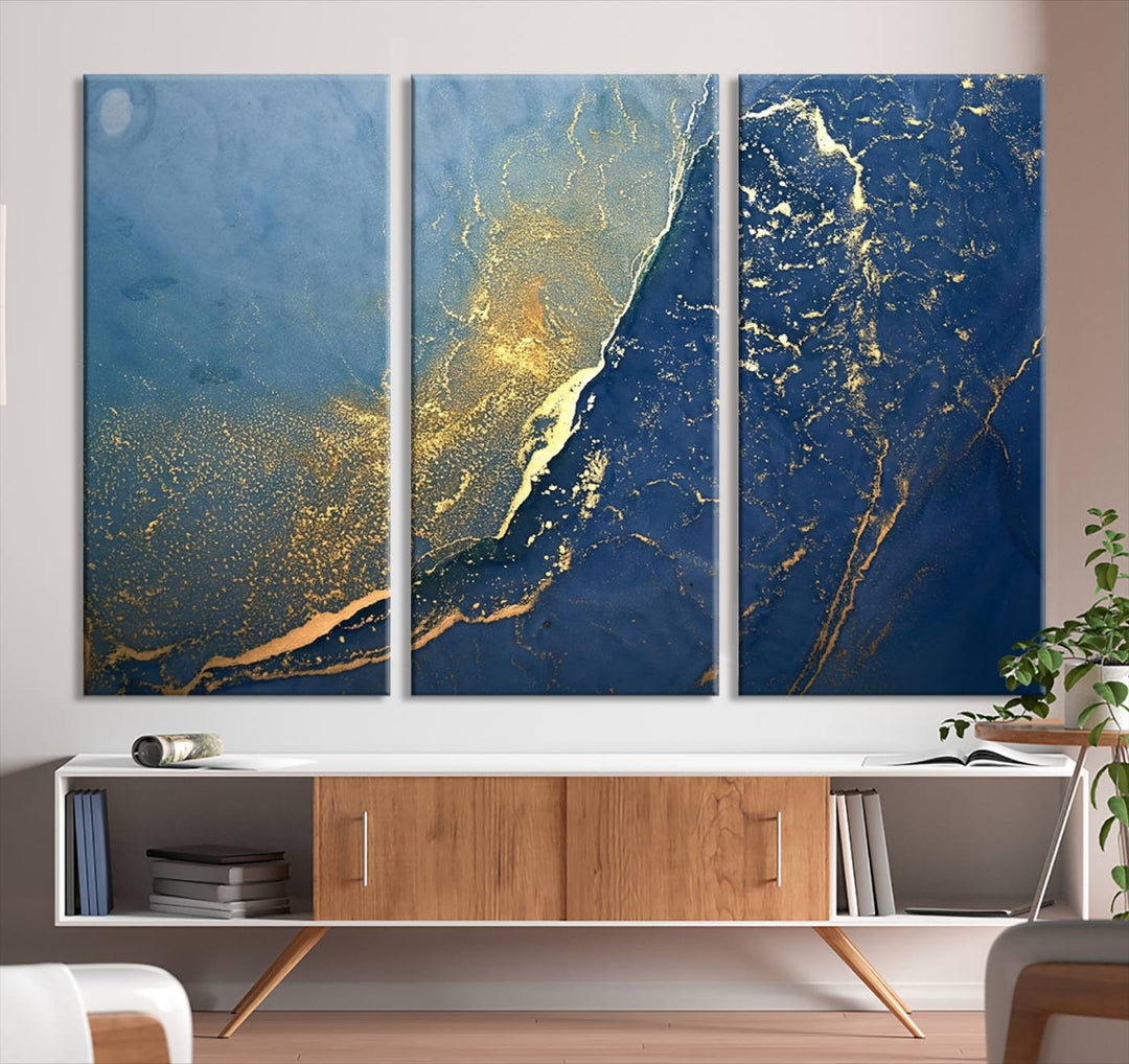 The Navy Blue Yellow Twinkle Wall Art Canvas Print, featuring an abstract design in gold and blue, enhances a modern living room as it adorns a white wall with its gallery-wrapped, museum-quality canvases for an exquisite touch.