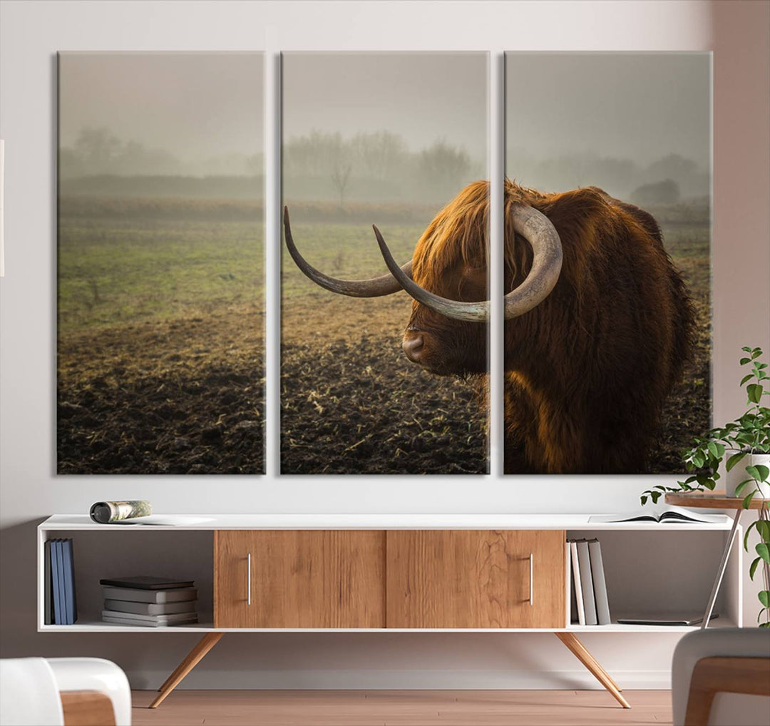 The "Big Cow Horn Wall Art Canvas Print" is a hand-assembled framed canvas depicting a Highland cow in a misty field. It is crafted with a UV-protective coating to ensure lasting vibrancy.